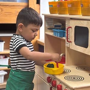 A child exploring the play kitchen in a Kid's Country classroom
